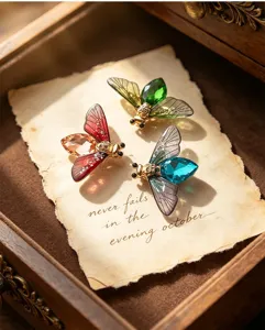 Vintage crystal insect brooch detailed view, gradient transparent wings, elegant coat accessory.