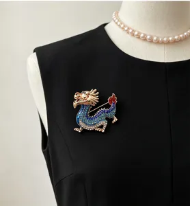 Close-up of a vintage Chinese zodiac dragon brooch with blue rhinestones and gold-tone metal.