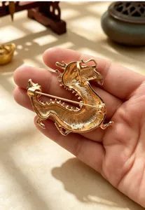 Detail view of vintage gold dragon brooch showing back pin structure and metallic texture.