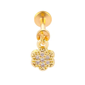 Nahaufnahme von goldfarbenem Edelstahl-Piercingschmuck mit funkelndem Kristall-Blumenanhänger.