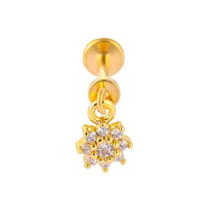 Nahaufnahme des funkelnden Zirkonia-Blumenanhängers an dem goldenen Piercing-Stecker Detail.