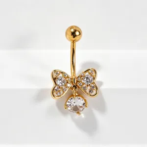Close-up of a gold-tone butterfly belly button ring with sparkling zirconia stones.