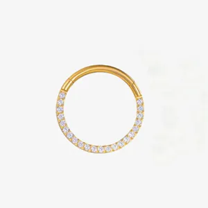 Close-up of gold titanium hinged segment ring featuring shimmering zirconia crystals for piercing.