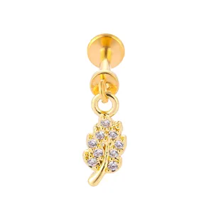 Close-up detail of gold titanium steel labret lip ring with cubic zirconia leaf charm.