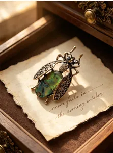 Detailed shot of vintage insect brooch, antique bronze moth pin with green shell texture.