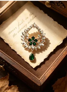 Vintage emerald wreath brooch with crystal waterdrop pendant, elegant retro jewelry piece.