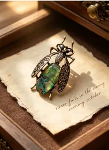 Vintage abalone shell insect brooch detail shot, bronze filigree wings and crystal accents.