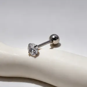 Detailed close-up of stainless steel tongue piercing with sparkling prong-set cubic zirconia.