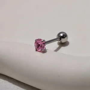 Close-up detail of stainless steel body piercing tongue stud featuring a pink crystal stone.