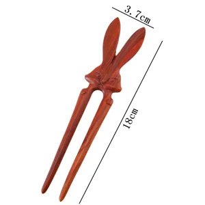 Close-up of the delicate rabbit-shaped wooden hairpin, highlighting smooth carved sandalwood details.