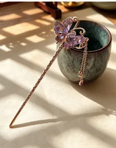 Detail shot of ancient Chinese style butterfly hair stick with purple crystals and tassel.