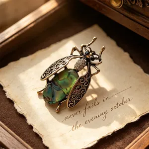Vintage insect moth brooch with imitation abalone shell body and bronze filigree wings main view.