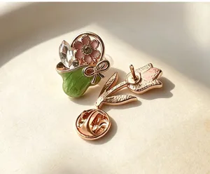 Close-up detail of retro enamel flower basket and tulip brooch pin for clothing decoration.