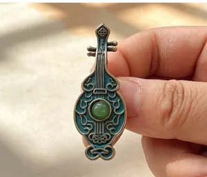 Exquisite Chinese style pipa brooch featuring imitation enamel craftsmanship and a green bead accent.