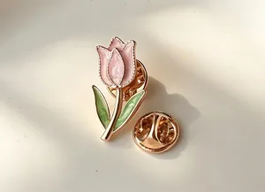 Close-up detail of the elegant pink tulip enamel brooch with gold trim and secure clasp.