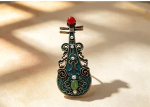 Close-up detail of retro Chinese style Pipa brooch with enamel and faux pearls.