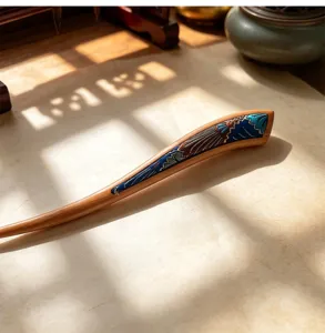 Exquisite detail shot of traditional Chinese wooden hair stick with blue wave embroidery.