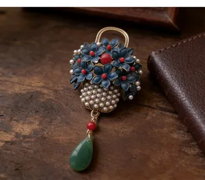 Vintage enamel flower basket brooch with pearls, red beads, and green teardrop tassel pendant.