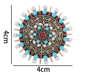 Gros plan detail de broche soleil style tibetain vintage avec alliage et perles turquoise.