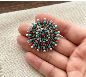 Vue de détail de la broche soleil de style ethnique avec alliage et perles rétro.