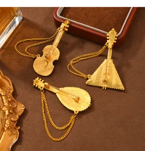 Vista detallada de broches de instrumentos con borlas vintage creativos en metal dorado.