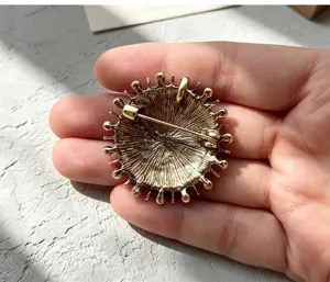 Vue détaillée de broche soleil en alliage rétro avec fermoir de sécurité et anneau pendentif.