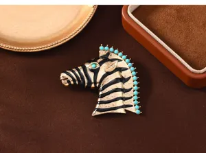 Vintage zebra brooch close-up, alloy enamel finish with turquoise beads and green crystal eye detail.
