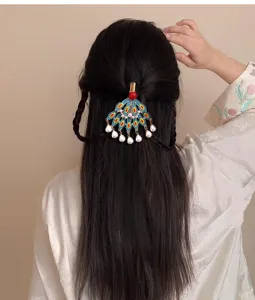 Detail shot of Chinese traditional Dunhuang style peacock feather hairpin with pearls.