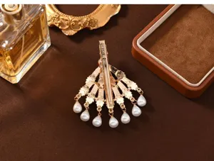 Detailed view of a vintage Chinese style hair clip with pearl pendants on brown background.