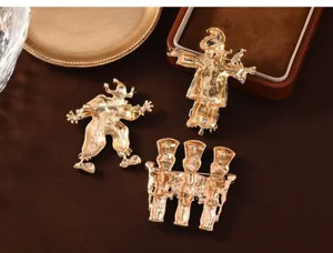 Back detail view of vintage gold-tone enamel clown and scarecrow brooches clearly showing pins.