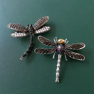Exquisite dragonfly brooch detail featuring rhinestone and enamel craftsmanship for elegant outfits.
