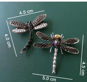 Detailed view of rhinestone dragonfly brooch featuring exquisite enamel and crystal details.