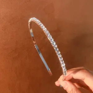 Close-up detail of a slender rhinestone hair hoop sparkling with brilliant zircon stones.