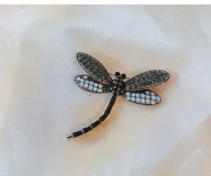 Close-up detail of a stunning dragonfly brooch adorned with rhinestones and enamel details.