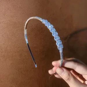 Detailed view of elegant silver rhinestone headband, sparkling crystal hair accessory.