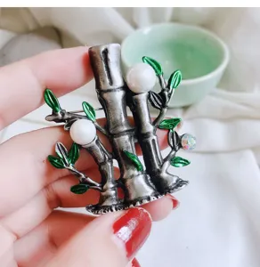Vintage bamboo pearl brooch, green enamel leaves, antique silver metal jewelry detail.