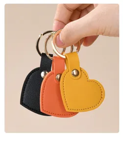 Primer plano de tres coloridos llaveros de corazón de cuero en negro, naranja y amarillo