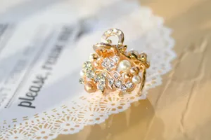 Mini pearl flower hair claw clip detail shot, elegant gold hair accessory for women.