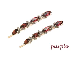 Gros plan détaillé de longue pince à cheveux en strass avec des cristaux navette violets.