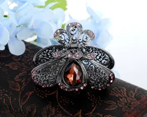 Molla per capelli da donna in metallo scuro con strass rosa e cristallo per look elegante.