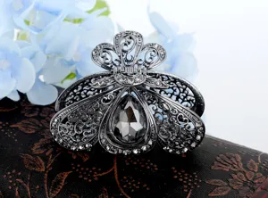 Dettaglio ravvicinato della molletta per capelli in lega gunmetal con strass e cristallo.