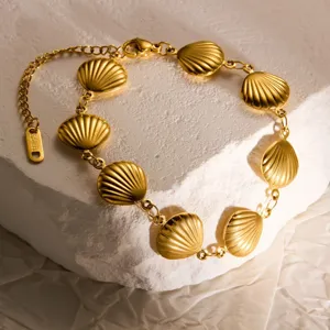 Primer plano de pulsera de conchas de acero inoxidable dorada, estilo de verano.