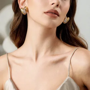 Nahaufnahme von vintage goldenen Herz-Ohrringen mit funkelnden Strasssteinen, elegante Details.