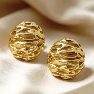 Close-up detail shot of vintage textured gold stud earrings, showing unique metallic surface.