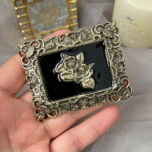 Vintage rose relief brooch detail shot, baroque metal black enamel accessory display.
