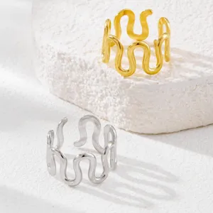 Close-up of minimalist wave rings in gold and silver finish, stainless steel jewelry.