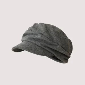 Primo piano del cappello gavroche grigio plissé, con morbida trama lavorata a maglia fine.