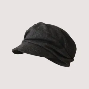 Primo piano di coppola grigia scura plissettata, ottimi dettagli della texture del cappello.