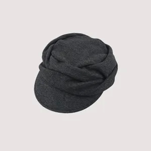Dettaglio del berretto newsboy plissettato grigio scuro, cappello piatto vintage retrò.