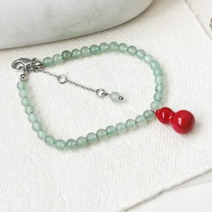Detail shot of green aventurine bead bracelet featuring a vibrant red gourd pendant and clasp.